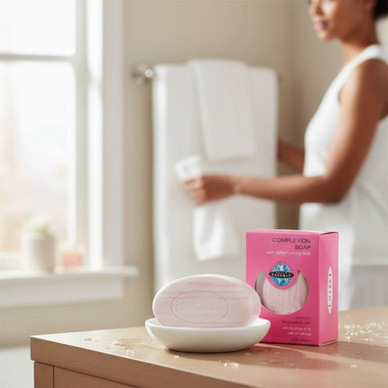 Tia's Treasure Collections Clear Essence Alpha Hydroxy complexion soap bar on a white dish with its pink packaging.