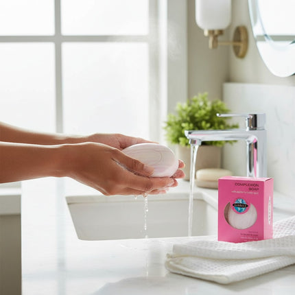 Tia's Treasure Collections Clear Essence Alpha Hydroxy Complexion Soap bar being lathered under a bathroom faucet