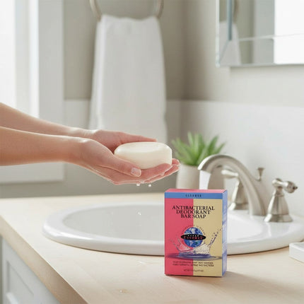 Tia's Treasure Collections Clear Essence antibacterial deodorant bar soap held in hands over a bathroom sink.