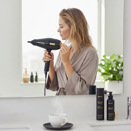 Tia's Treasure Collections Babyliss 4Barber Influencer Edition black hair dryer being used by a woman in a bathroom