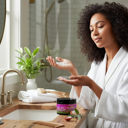 Tia's Treasure Collections Blaq Luxury Sage and Lyche hair masque jar on a bathroom vanity with a woman applying cream