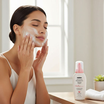 Tia's Treasure Collections Clear Essence brightening foaming cleanser bottle next to a woman washing her face