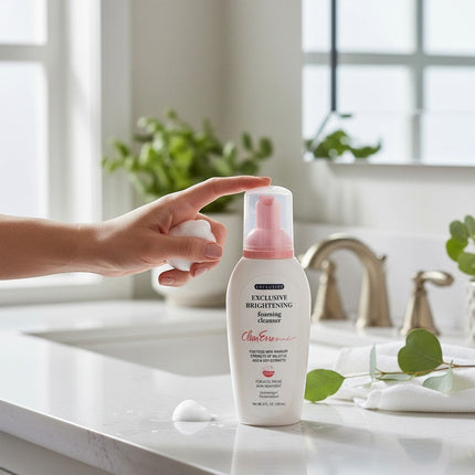 Tia's Treasure Collections Clear Essence Exclusive Brightening Foaming Cleanser bottle on a bathroom vanity.