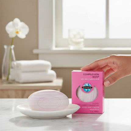 Tia's Treasure Collections Clear Essence Alpha Hydroxy Complexion Soap bar and pink packaging on a white dish