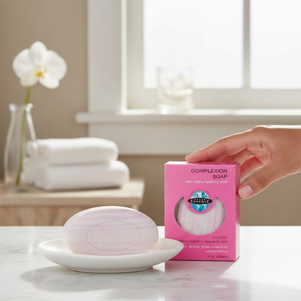 Tia's Treasure Collections Clear Essence Alpha Hydroxy Complexion Soap bar and pink packaging on a white dish